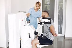 Patient doing exercise using equipment with therapist